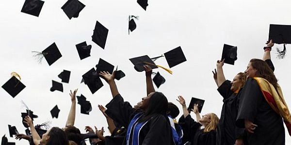 A Group of Happy Graduate Students Throwing Their Caps In The Air.